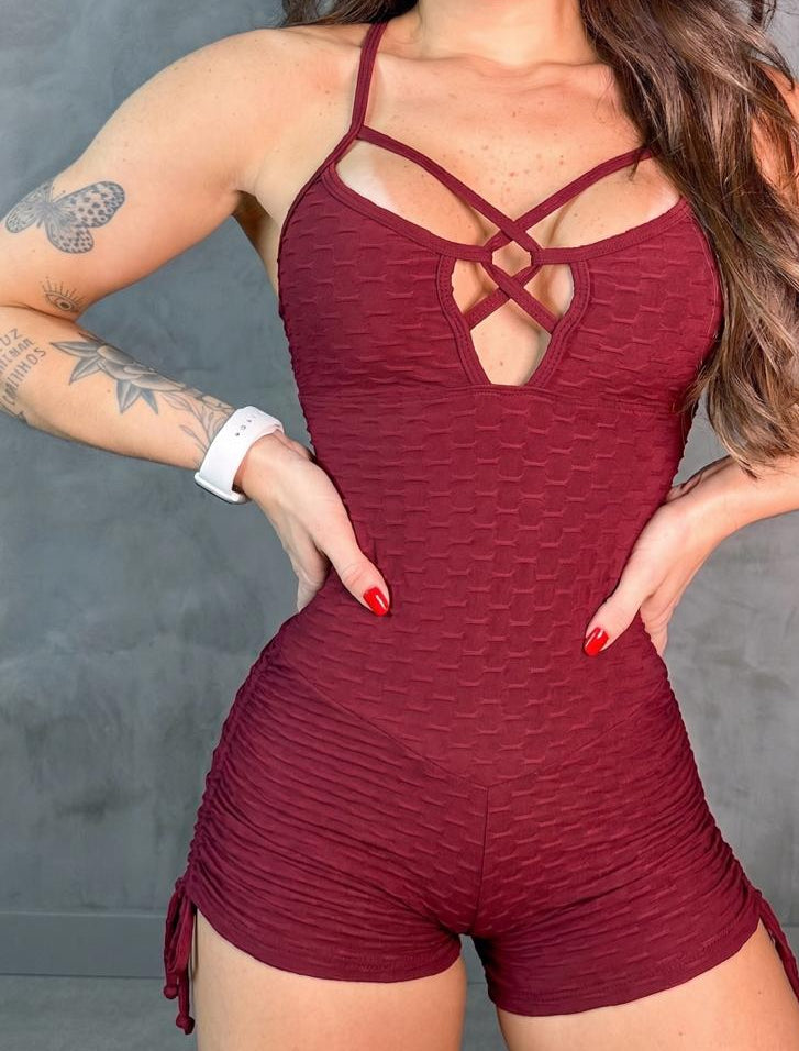 Person wearing a red romper with a gray background