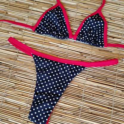 Polka dot bikini with red straps on a woven mat